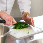 Une personne découpe des fines herbes en cuisine