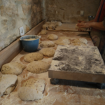 Un homme façonne des boules de pain dans son fournil