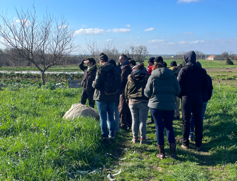 Un groupe de personnes visite les champs d'une ferme