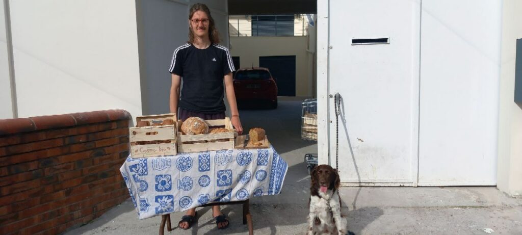 Rémi, boulanger, pose avec ses pains