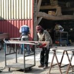 Une personne travaille une planche de bois dans un hangar