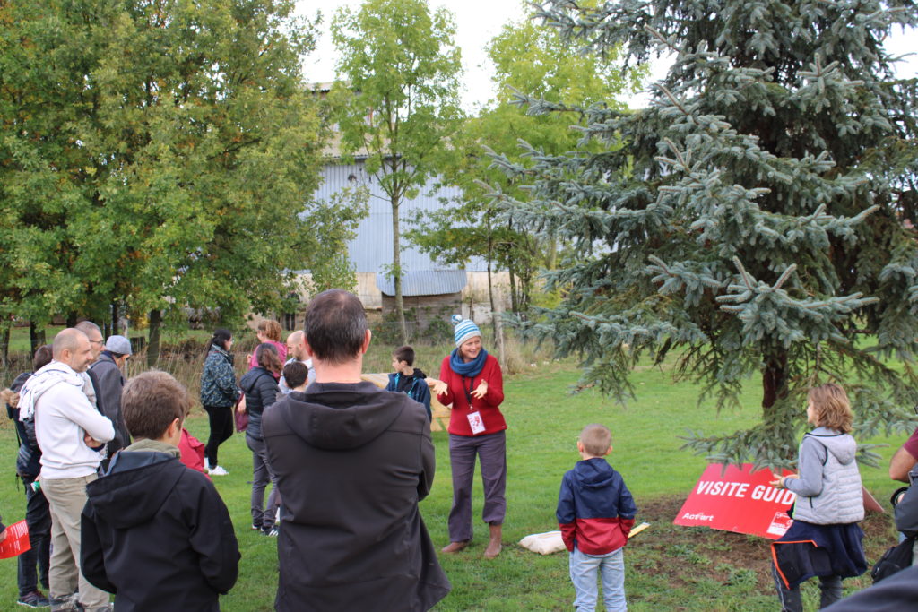 Des adultes et enfants sont rassemblés en extérieur pour une animation ludique