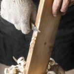 Gros plan sur une personne qui travaille une planche de bois