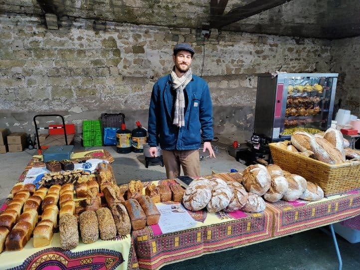 Vivian devant son stand de pains dans une grange